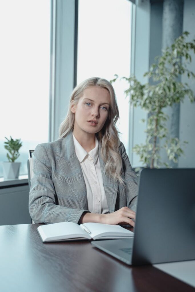 pexels-photo-5717546 Portrait of a confident businesswoman working on her laptop in a modern office setting.